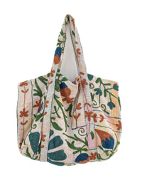 Flerfarvet blomsterbroderet quiltet tote-taske med botanisk mønster og skulderstropper på hvid baggrund