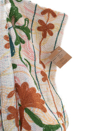 Nærbillede af vintage quiltet vest med blomsterbroderi i pastelfarver med brune og grønne botaniske detaljer