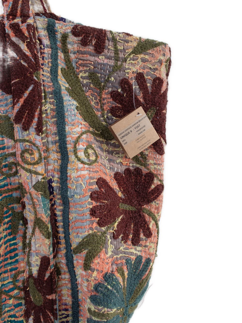 Nærbillede af håndlavet broderet blomstermønstertaske i flerfarvet patchworkstof med teksturerede bordeaux- og blågrønne blomster