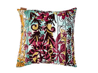 Bunter Suzani-Kissenbezug 50x50 cm mit türkisfarbenem, burgunderrotem und gelbem Muster, schwarzen Blumen und Girlandenornamenten im Boho-Vintage-Oriental-Stil.